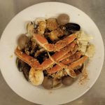 A white plate with crabs and clams on it.